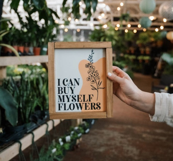 I can buy myself flowers song quotes on a wood sign with flowers being held